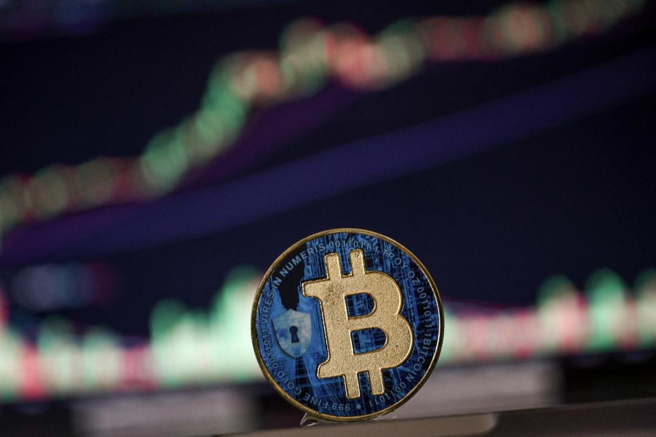 Photo illustration shows  a coin imitation of the Bitcoin cryptocurrency arranged beside a screen displaying a trading chart on Nov. 22, 2024. (AFP Photo)