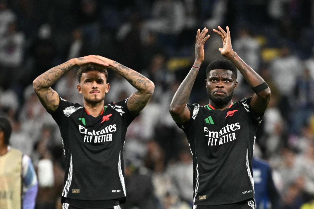Arsenals English defender #04 Ben White and Arsenals Ghanaian midfielder #05 Thomas Partey (R) celebrate victory at the end of the UEFA Champions League quarter final second leg football match between Real Madrid CF and Arsenal at Santiago Bernabeu Stadium in Madrid on April 16, 2025. (AFP Photo)