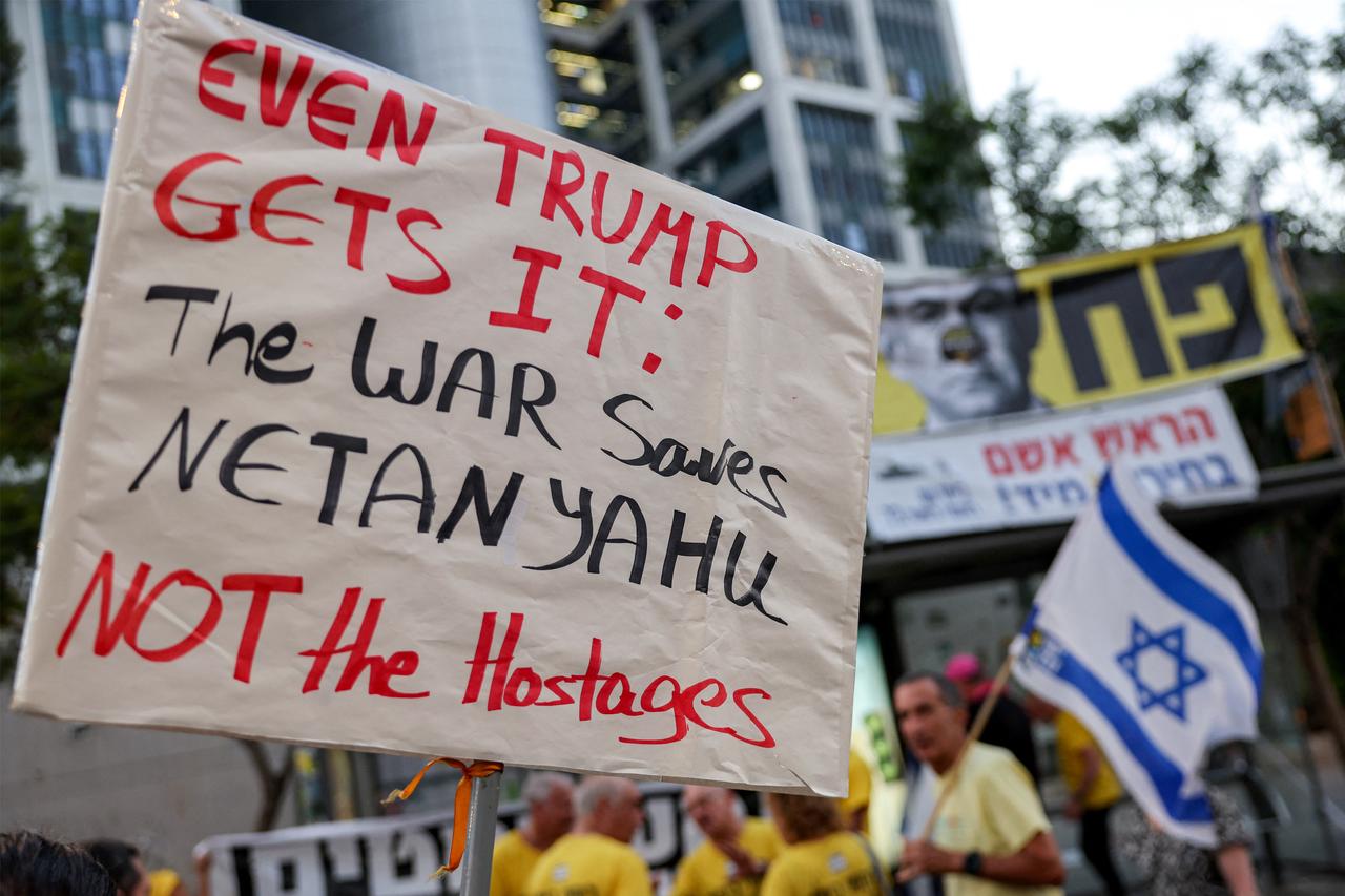 A demonstrator poses with a placard during an anti-government protest calling for action to secure the release of Israeli hostages outside the Israeli Defence Ministry headquarters in Tel Aviv on July 5, 2025. (AFP Photo)