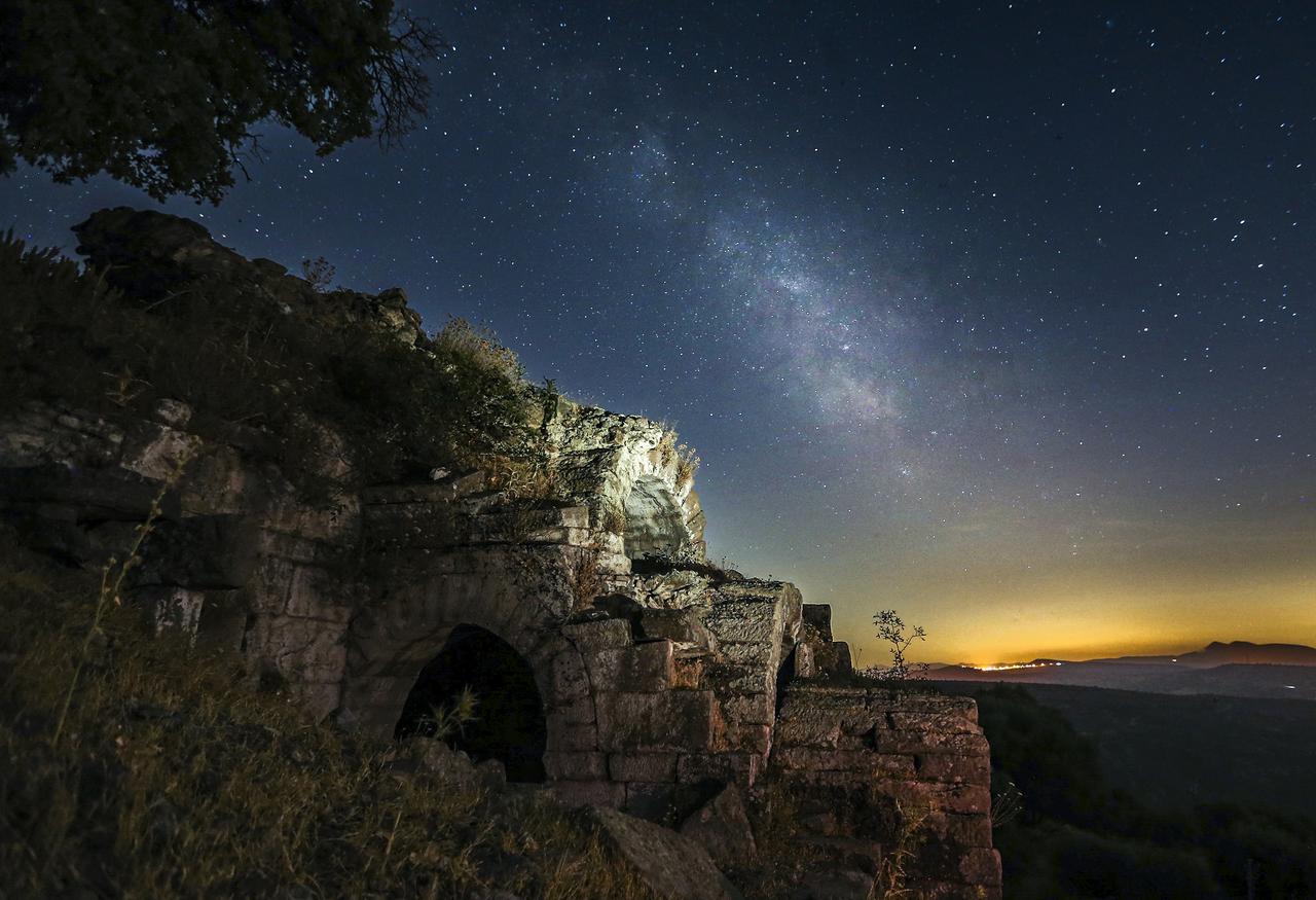 A long exposure photo shows a night sky full of stars and Milky Way with vomitorium (audience entrance) of the theater, which is a vaulted passage through which the audience enters and exits the building, at Aigai Ancient City in Yunusemre district of Manisa, Türkiye on July 03, 2024. (AA Photo)