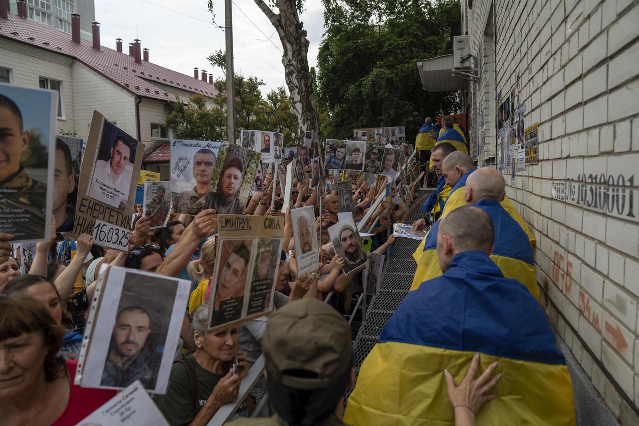 Ukrainian military personnel of the Armed Forces, the National Guard, the State Border Guard Service and the State Special Transport Service are seen with national flags draped over their shoulders after returning Ukraine as relatives of the Ukrainian soldiers hold portraits of the soldiers on July 04, 2025 in Chernihiv region of Ukraine. (AA Photo)