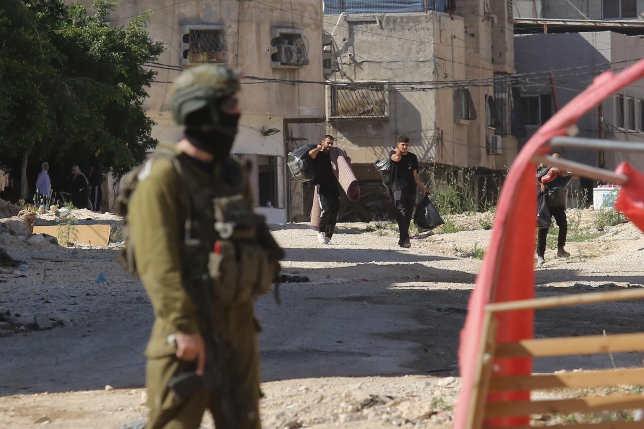 The Israeli army, which set up a checkpoint in Tulkarm Refugee Camp, allows Palestinians to take items from their homes after checking their identity cards in Tulkarm, West Bank on July 6, 2025. (AA Photo)