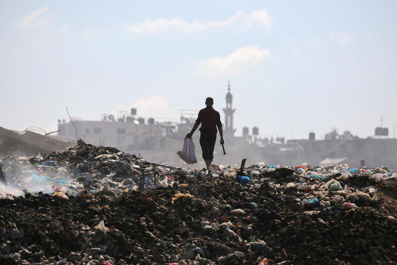 A Palestinian man searches for things to rescue at a garbage waste dump in the Al-Bureij camp in the central Gaza Strip on July 7, 2025. (AFP Photo)
