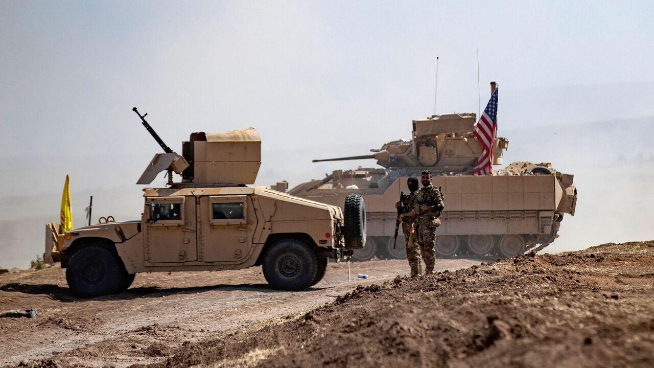 Members of the terrorist group PKK/YPG-led SDF stand near a US Bradley Fighting Vehicle (BFV) during a joint military exercise with forces of the US-led "Combined Joint Task Force-Operation Inherent Resolve" coalition in Syria's northeastern al-Hasakah province on September 7, 2022. (AFP Photo)