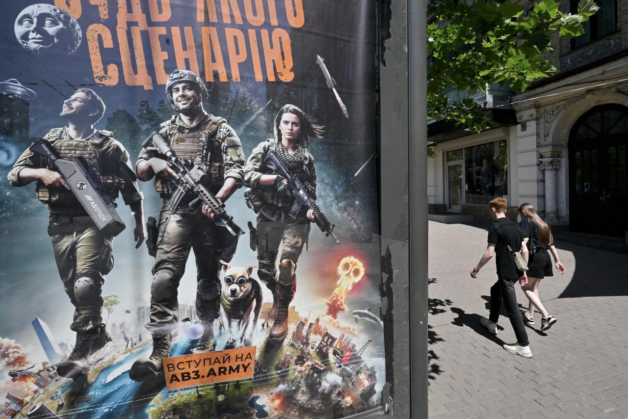 A couple walks past a recruiting placard of the Third Assault Brigade of the Armed Forces of Ukraine, reading "Preparing for any scenario", in Kyiv on July 6, 2025. (AFP Photo)