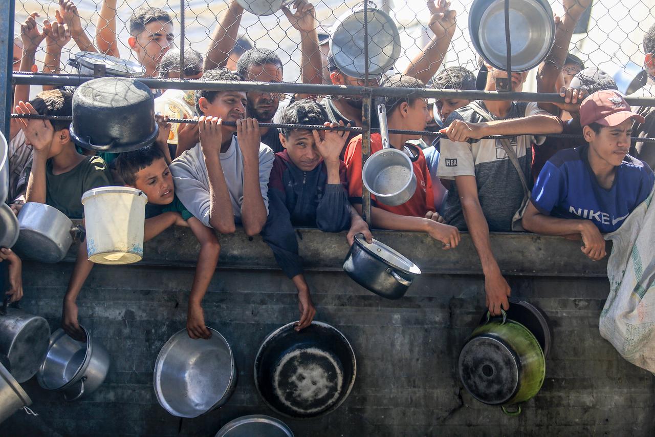 Palestinians gather for receive food on July 03, 2025 in Khan Yunis, Gaza. (AA Photo)
