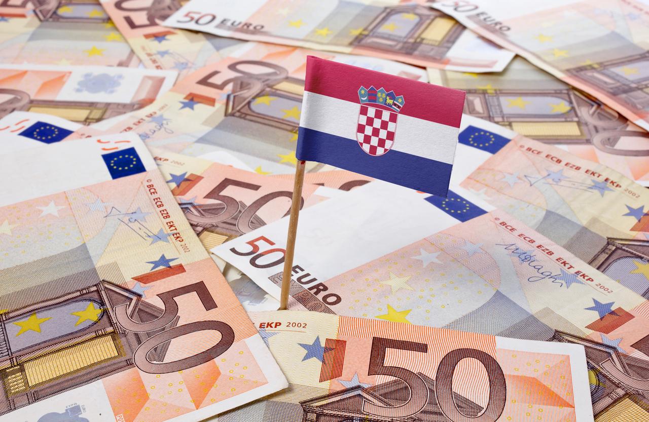 A Croatian flag placed among euro banknotes. (Adobe Stock Photo)
