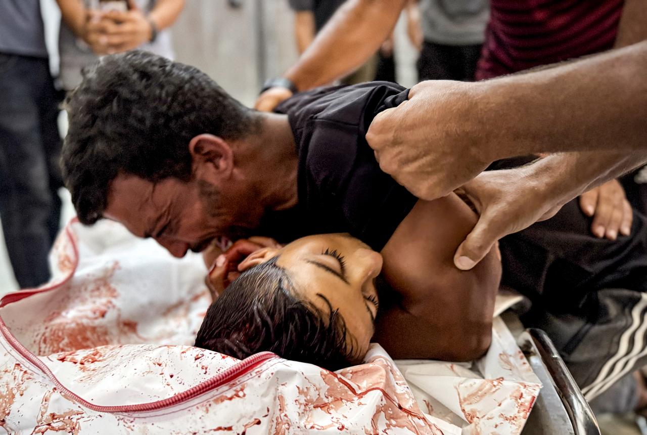 Young man mourns over the body of a child, identified as Reyyan al-Fuqaha, who lost his life in an Israeli attack, Gaza, August 01, 2025. (AA Photo)