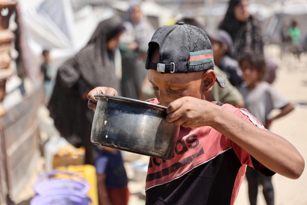 A Palestinian boy drinks lentil soup that he obtained at a food distribution point in Gaza City, Gaza, August 1, 2025. (AFP Photo)