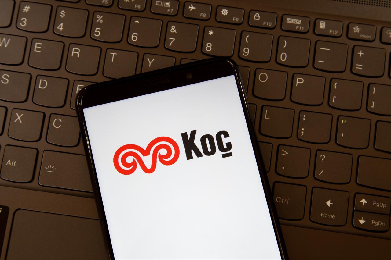 Image shows the Koc Holding logo on a smartphone screen placed on a keyboard (Adobe Stock Photo)