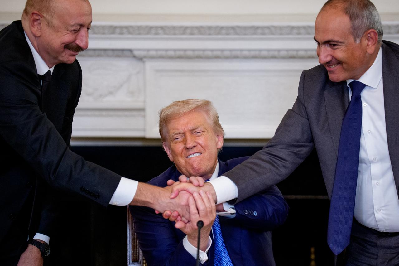 US President Donald Trump (C), Azerbaijani President Ilham Aliyev (L) and Armenian Prime Minister Nikol Pashinyan shake hands after signing an agreement in the State Dining Room of the White House in Washington, DC, on August 8, 2025.  (AFP Photo)