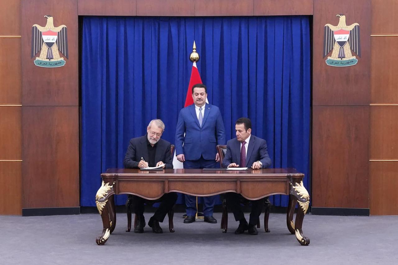 A handout picture released by Iraqs Prime Ministers Media Office shows Prime Minister Mohammed Shia al-Sudani (C) watching as Ali Larijani (L), Irans head of the National Security Council, and Iraqs National Security Adviser Qassem al-Araji sign a bilateral security agreement in Baghdad, Iraq, August 11, 2025. (AFP Photo)
