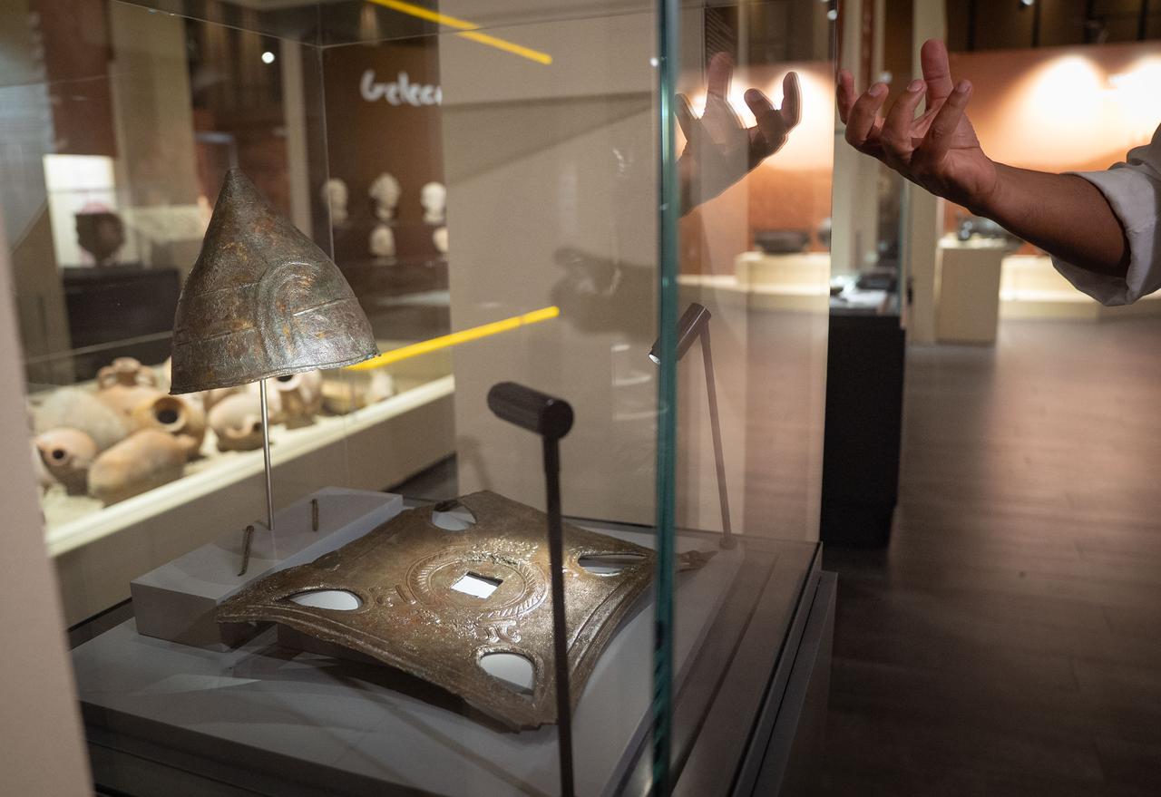 A bronze helmet decorated with mythological figures and an architectural facing plate, unearthed from the Haldi Temple in Van, are displayed at the “Golden Age of Archaeology” exhibition at the Presidential Library in Ankara, Türkiye, August 9, 2025. (AA Photo)