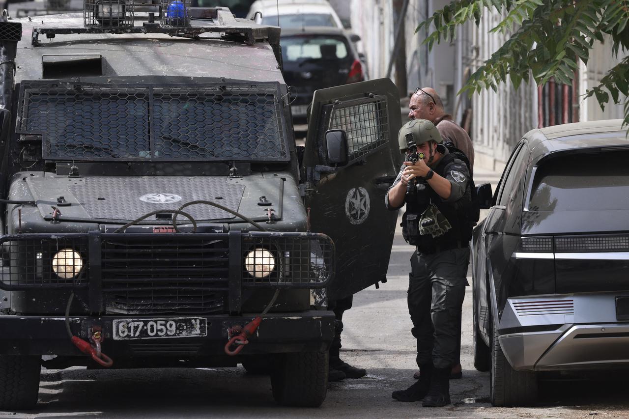 An Israeli soldier aims his weapon during a raid at the Balata refugee camp east of Nablus city in the occupied West Bank, Palestine, August 11, 2025. (AFP Photo)