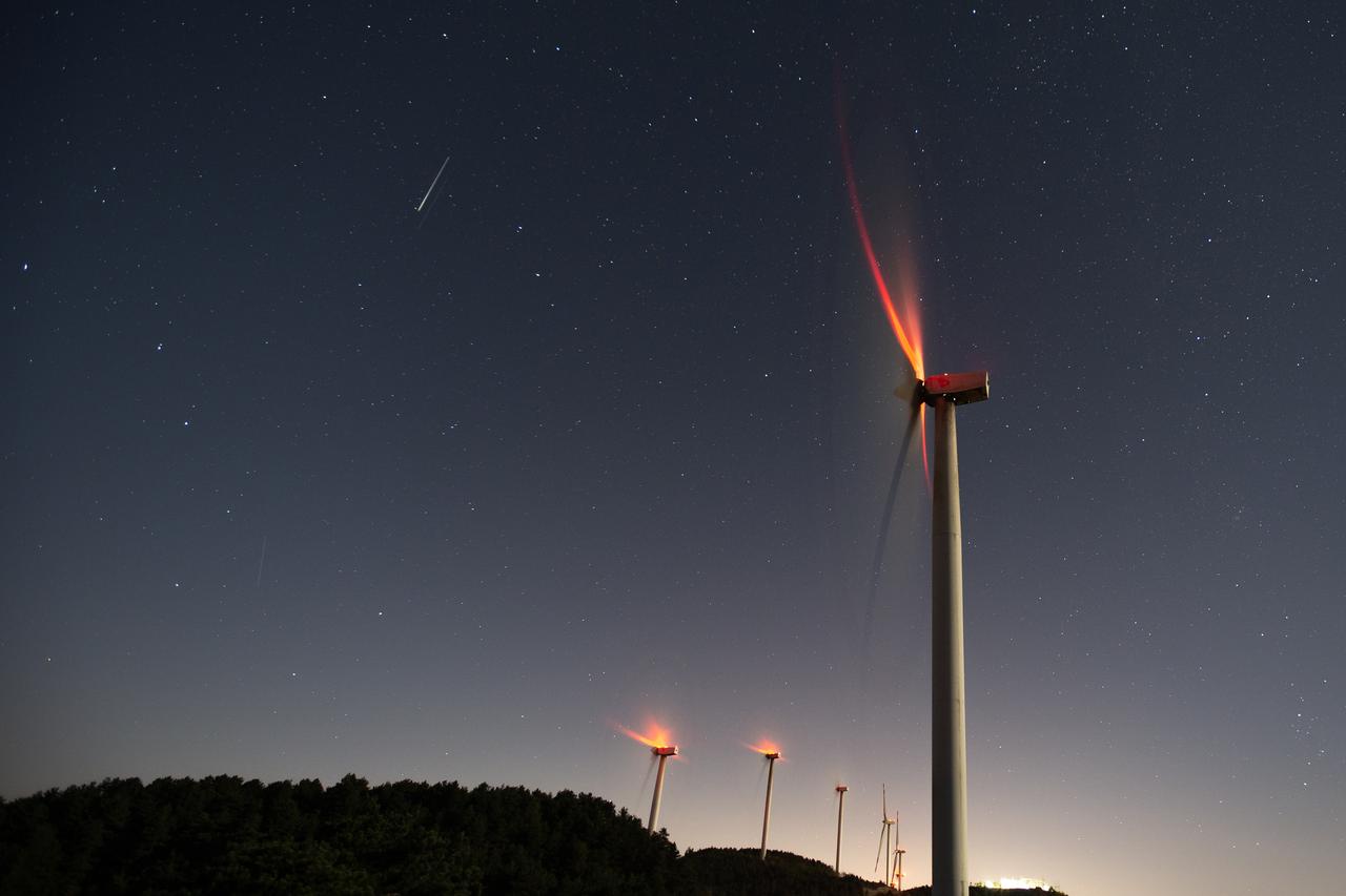A long-exposure photo shows rotating wind turbines and stars during the Perseid meteor shower in Hatay, Türkiye, August 12, 2025. (AA Photo)