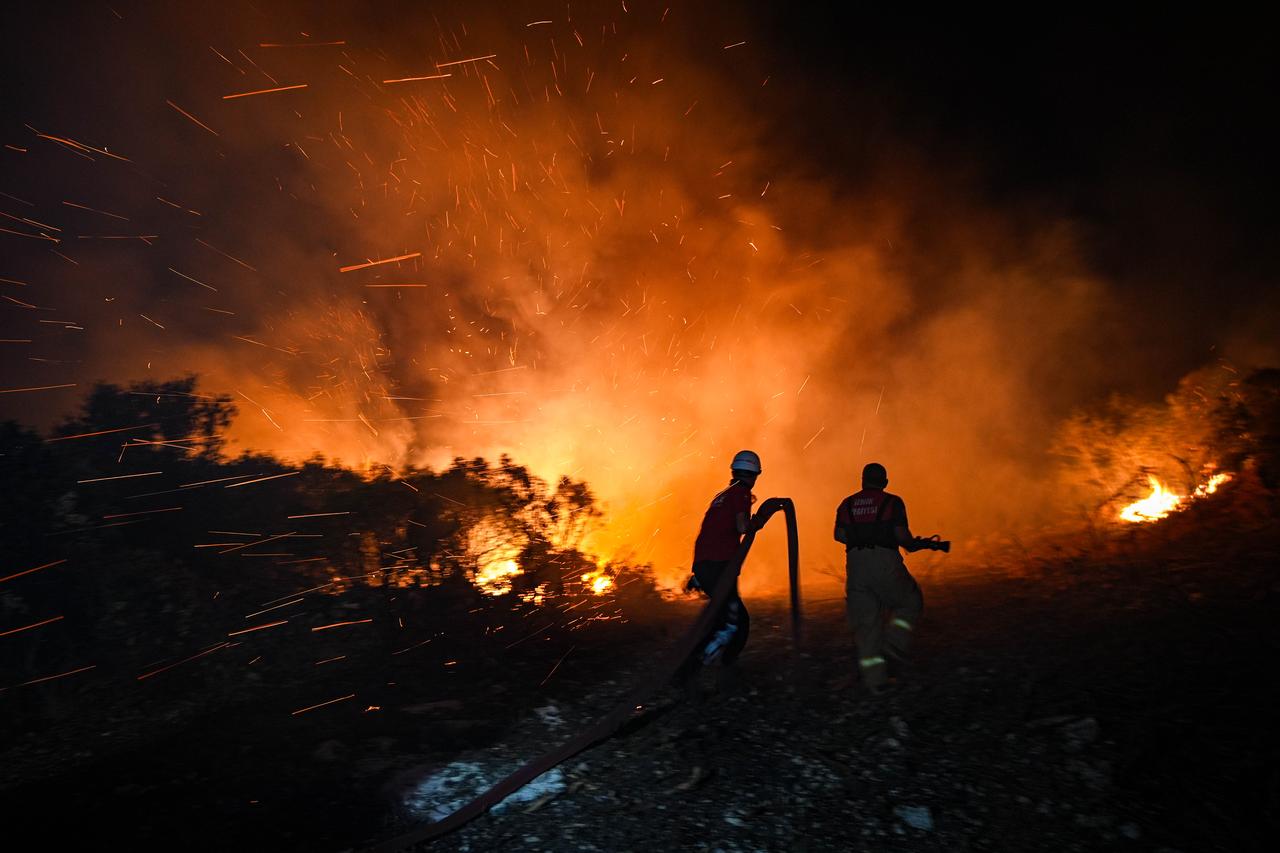 Smoke and flames rise as forestry, firefighting, and gendarmerie teams battle a blaze that spread from a minibus to a forested area in Izmir’s Buca district, Türkiye, Aug. 12, 2025. (AA Photo)