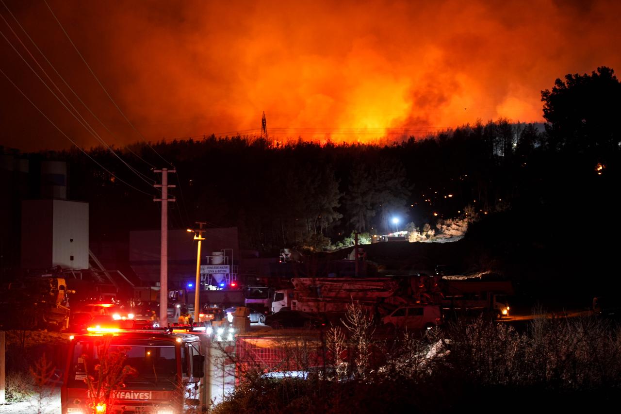 Flames engulf a forest in Izmir’s Buca district after a blaze from a minibus spread, as firefighters and aerial crews work to contain it, Aug. 12, 2025. (AA Photo)