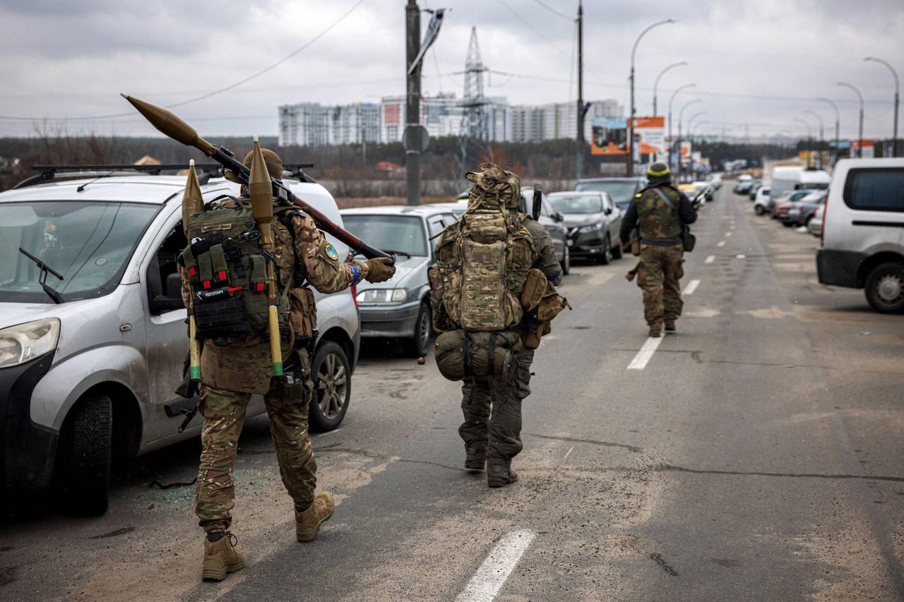 Ukrainian servicemen carry rocket-propelled grenades and sniper rifles as they walk toward the city of Irpin, northwest of Kyiv. (AFP Photo)
