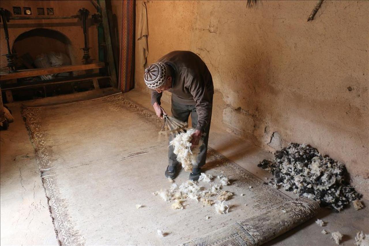 Ethem Hallac spreads raw wool on a mat as the first step in crafting a traditional kepenek in his workshop in Cal, Denizli, Türkiye, October 25, 2015. (AA Photo)