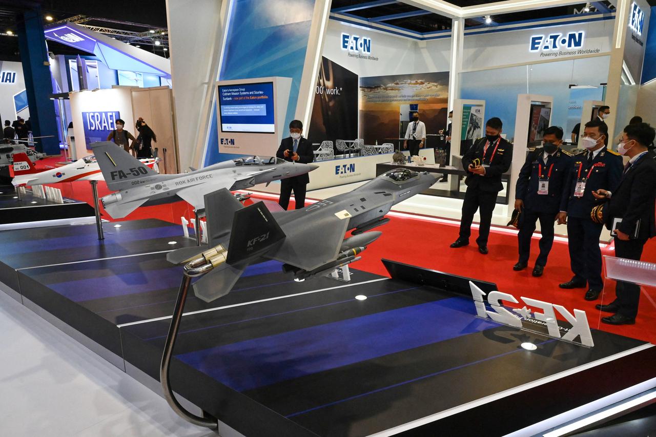 Visitors look at scale models (L-R) of the KT-1 trainer, FA-50 light combat aircraft, and KF-21 fighter manufactured by Korea Aerospace Industries (KAI) during the Singapore Airshow in Singapore on February 15, 2022. (AFP Photo)