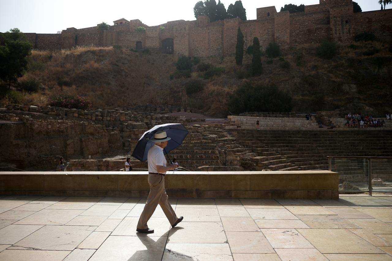 A man holds and umbrella to protect himself from the sun as he walks during a hot summer day in Malaga, Spain, August 5, 2025. (AA Photo)