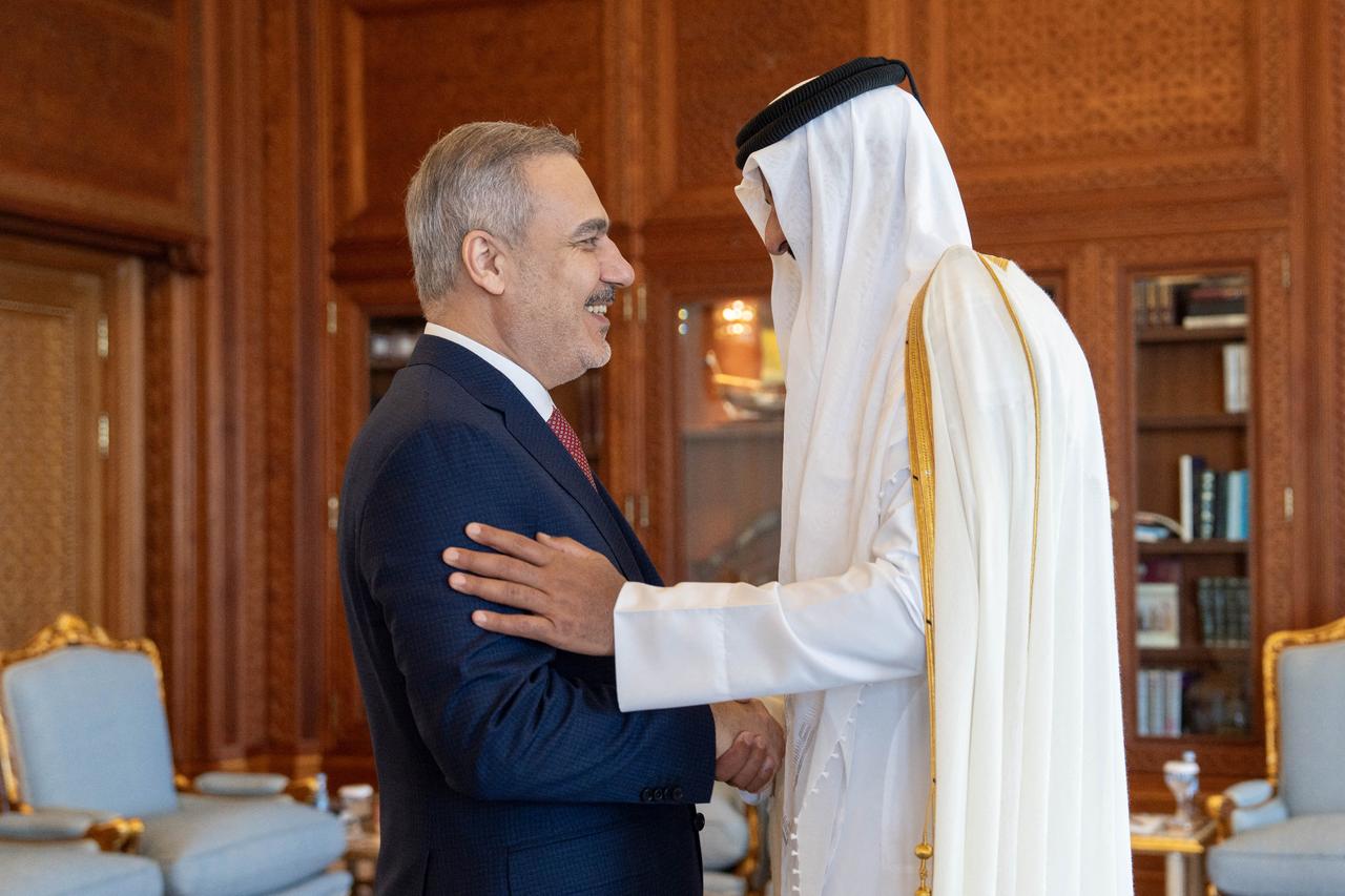 Qatars Emir Sheikh Tamim bin Hamad al-Thani (R) welcoming Foreign Minister Hakan Fidan in Doha on August 14, 2025. (Photo by Qatar Amiri Diwan / AFP)