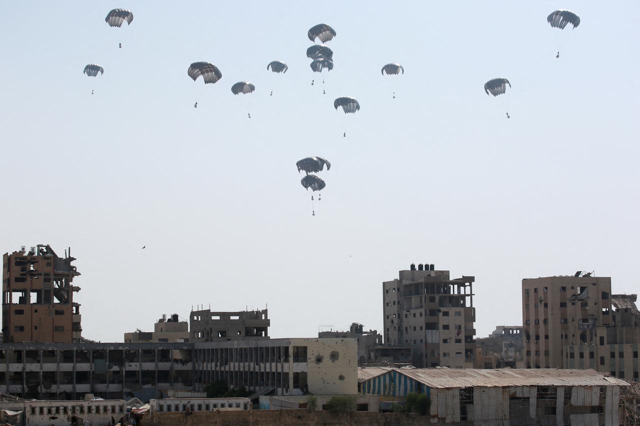 Aid packages parachute down near Jabalia in the northern Gaza Strip on August 14, 2025. (AFP Photo)
