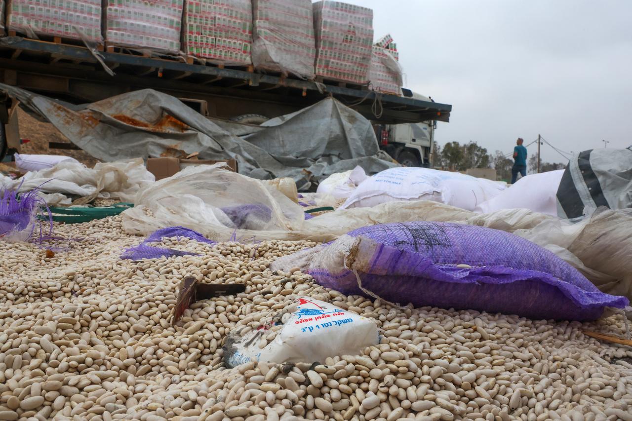 Damaged humanitarian aid for Palestinians in Gaza lies scattered on the ground next to broken-down trucks near the border with the Gaza Strip on August 13, 2025. (AFP Photo)