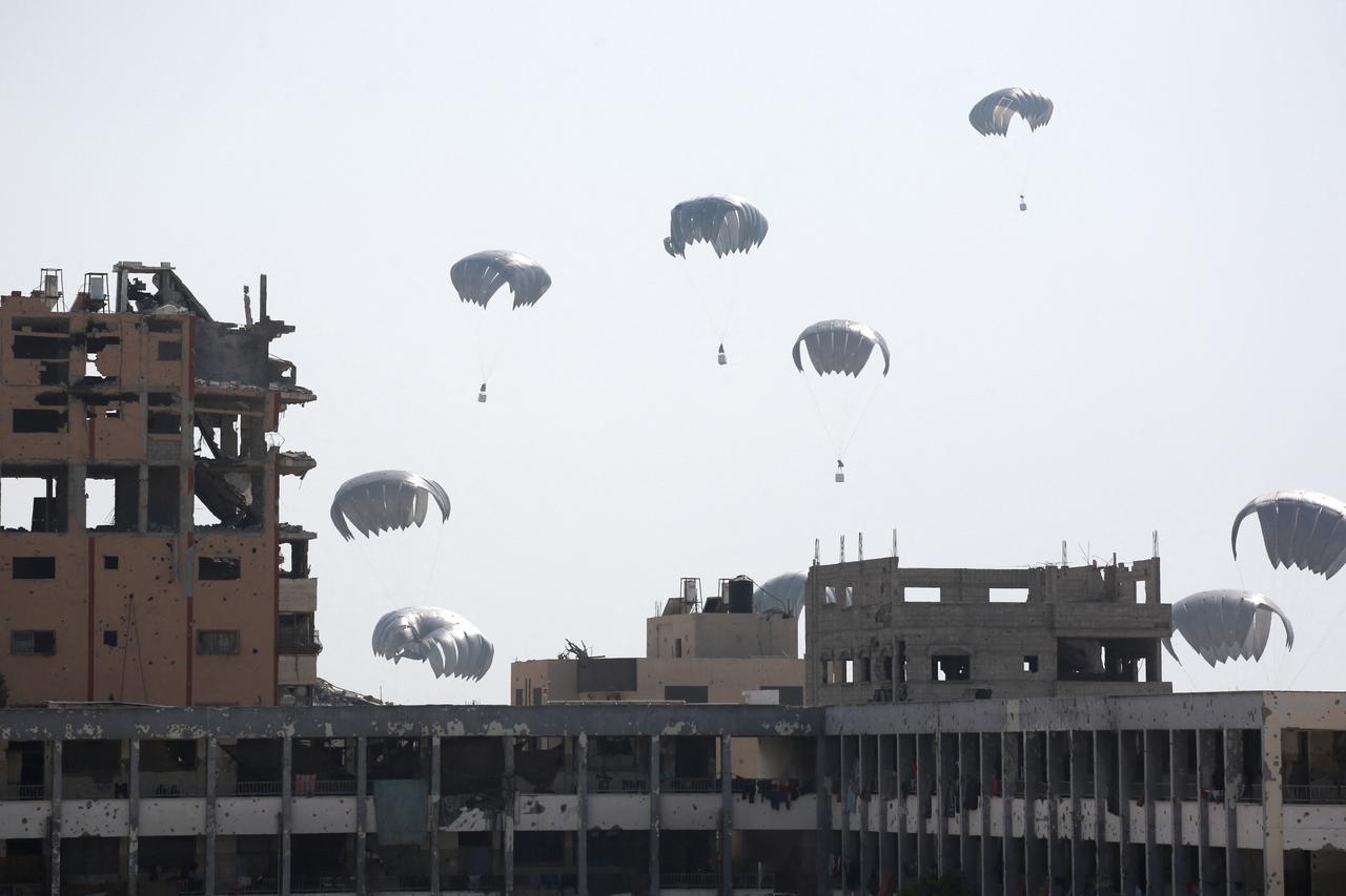 Aid packages parachute down near Jabalia in the northern Gaza Strip on August 14, 2025. (AFP Photo)