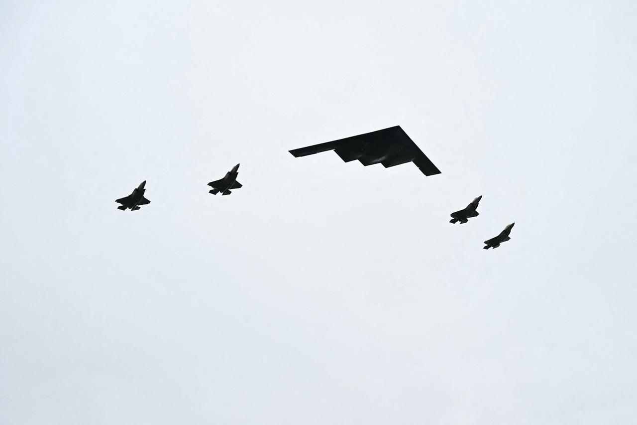 A B-2 bomber (C) and four F-35 fighter jets fly overhead as US President Donald Trump greets Russian President Vladimir Putin on the tarmac in Anchorage, Alaska, on August 15, 2025. (AFP Photo)