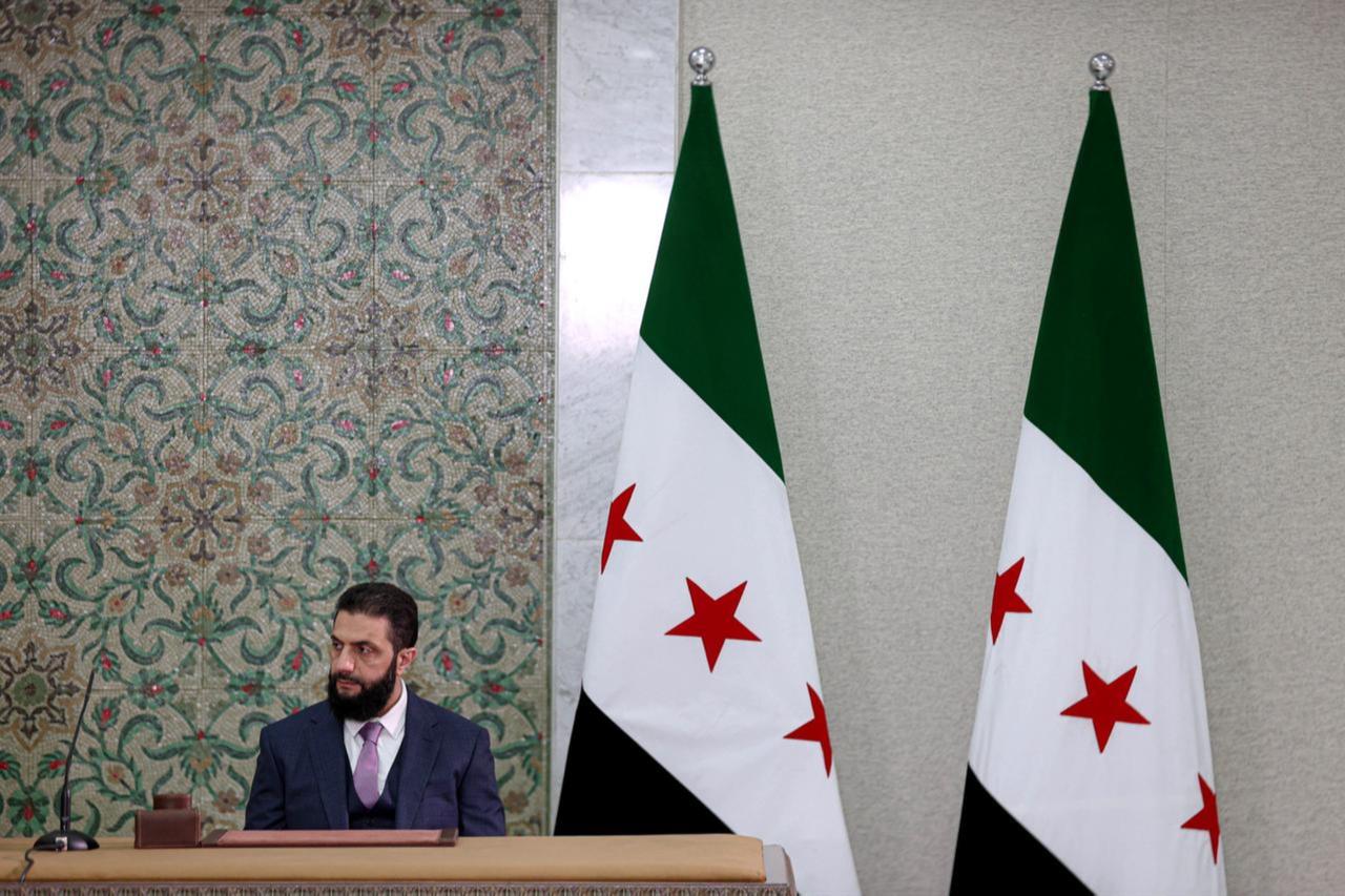 Syrian President Ahmed al-Sharaa signs a declaration outlining the main provisions of the interim constitution in a ceremony held at the Peoples Palace in the capital Damascus, Syria on March 13, 2025. (AA Photo)