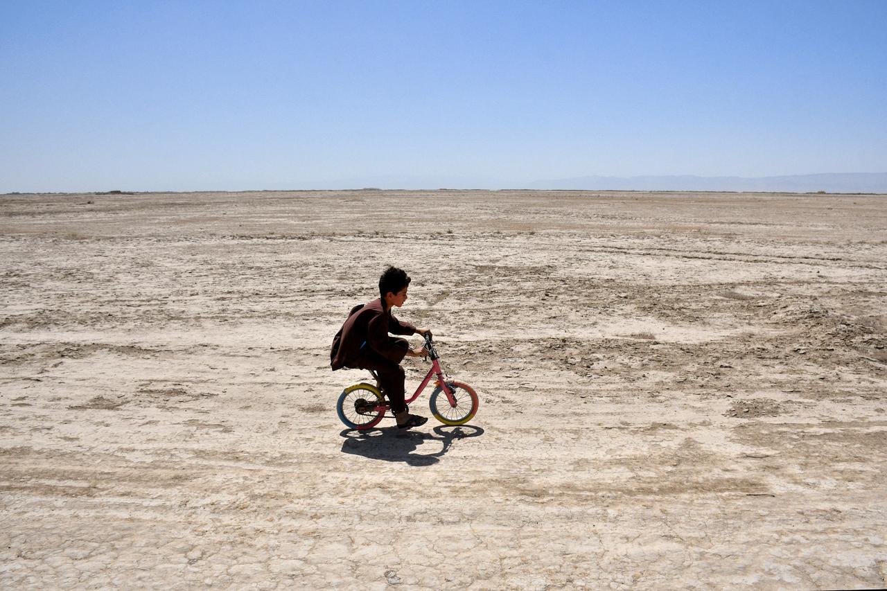 An Afghan child rides his bicycle along a deserted street in the drought-ridden village of Bolak at Chahar Bolak district, Balkh province, Afghanistan, July 10, 2025. (AFP Photo)