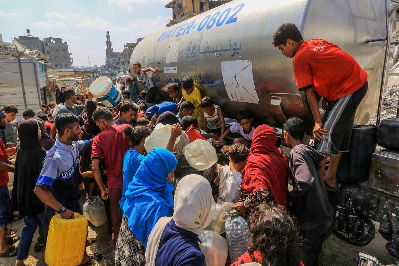 Palestinians try to fill their jerry cans from a water tanker in Khan Yunis, Gaza on August 18, 2025. (AA Photo)