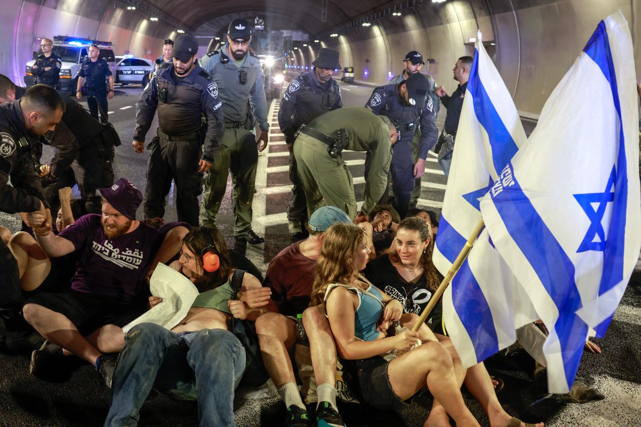 Israeli police remove demonstrators blocking traffic in a tunnel, as families and supporters of Israelis held hostage by Hamas militants in Gaza since the October 7, 2023. (AFP Photo)