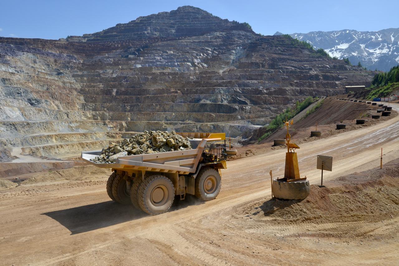 A dump truck carries ore at an open-pit mining quarry in the Austrian Alps, Austria. (Adobe Stock Photo)