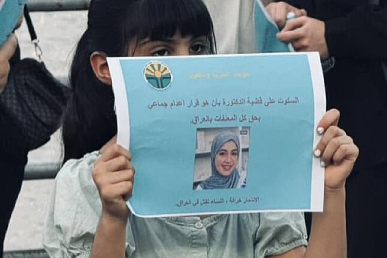 Photo of a girl holding a picture of Dr. Ban Ziyad during a protest demanding a fair investigation into her death. (Photo by @afadedrose)