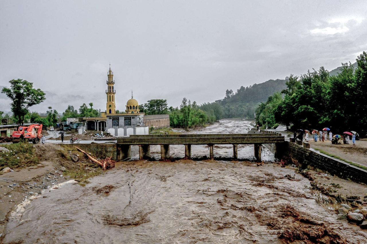 Villagers (R) stand near a bridge as floodwater levels rise in the Buner district of Pakistan's Khyber Pakhtunkhwa province, Pakistan, August 18, 2025. (AFP Photo)