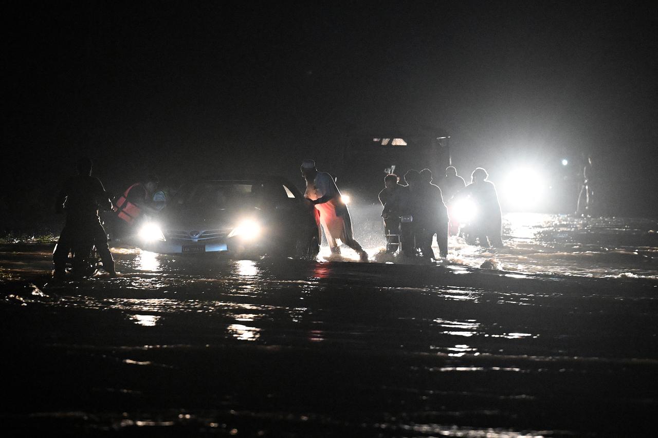 Residents wade through flooded street after a cloudburst in Dolari village, Swabi district, in northern Pakistan's mountainous Khyber Pakhtunkhwa province, August 18, 2025. (AFP Photo)