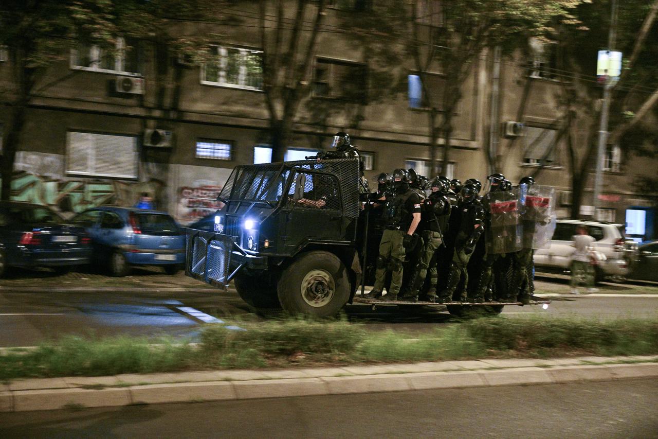 Serbian riot police officers travel on the back of a vehicle past burning garbage containers scattered along a road as the face protestors during ongoing anti-government protests in Belgrade, Serbia, August 18, 2025. (AFP Photo)