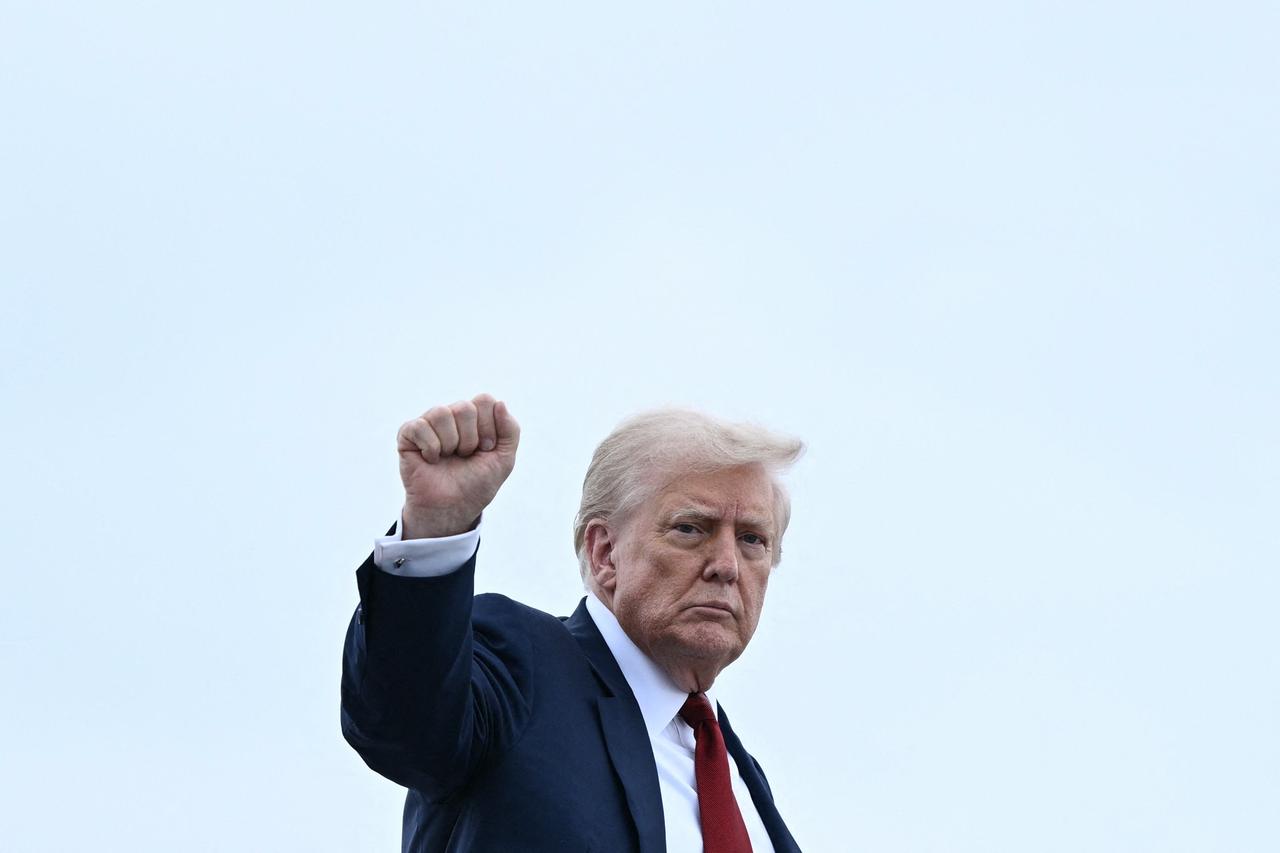 US President Donald Trump pumps his fist as he boards Air Force One at Joint Base Andrews, Maryland, on August 1, 2025. (AFP Photo)