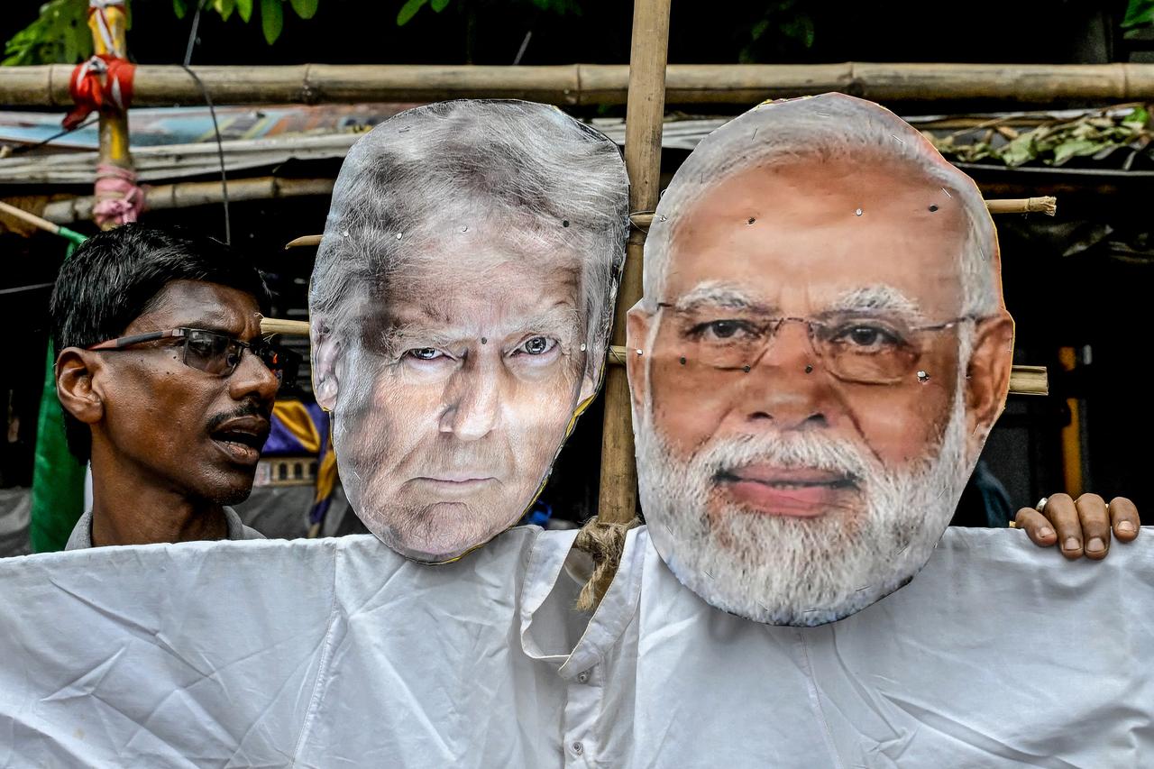 Congress activists carry an effigy of US President Donald Trump and Indian Prime Minister Narendra Modi as they protest against the Indo-US trade deal, after the former imposed 25 percent tariffs on Indian goods, during a demonstration in Kolkata on August 1, 2025. President Trump labelled Russia and US ally India  dead economies,  indicating that his threat to ramp up tariffs on New Delhi will now go ahead. India will face 25 percent tariffs while also announcing an unspecified  penalty  over New Delhis purchases of Russian weapons and energy. (Photo by Dibyangshu SARKAR / AFP)