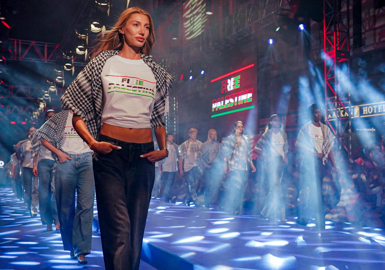 Models wearing outfits and keffiyehs bearing messages of support for the Palestinian people in Gaza walk on the runway during the fashion show in Istanbul, Türkiye, on August 18, 2025. (Photo AA )