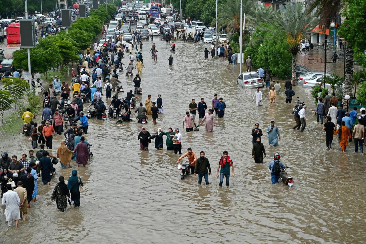People make their way through a waterlogged street following torrential rains in Karachi, Pakistan, August 19, 2025. (AFP Photo)