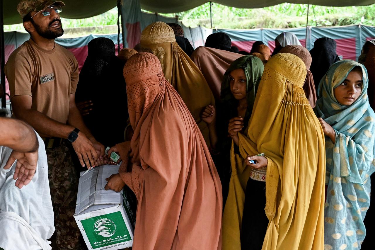 A soldier hands out relief supplies to women at a flood camp in Buner, Khyber Pakhtunkhwa, Pakistan, August 19, 2025. (AFP Photo)