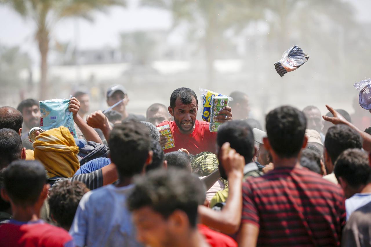 Humanitarian aid is airdropped by parachutes over the city as Palestinians run towards to the packages in Deir al-Balah, Gaza, on August 18, 2025. (AA Photo)