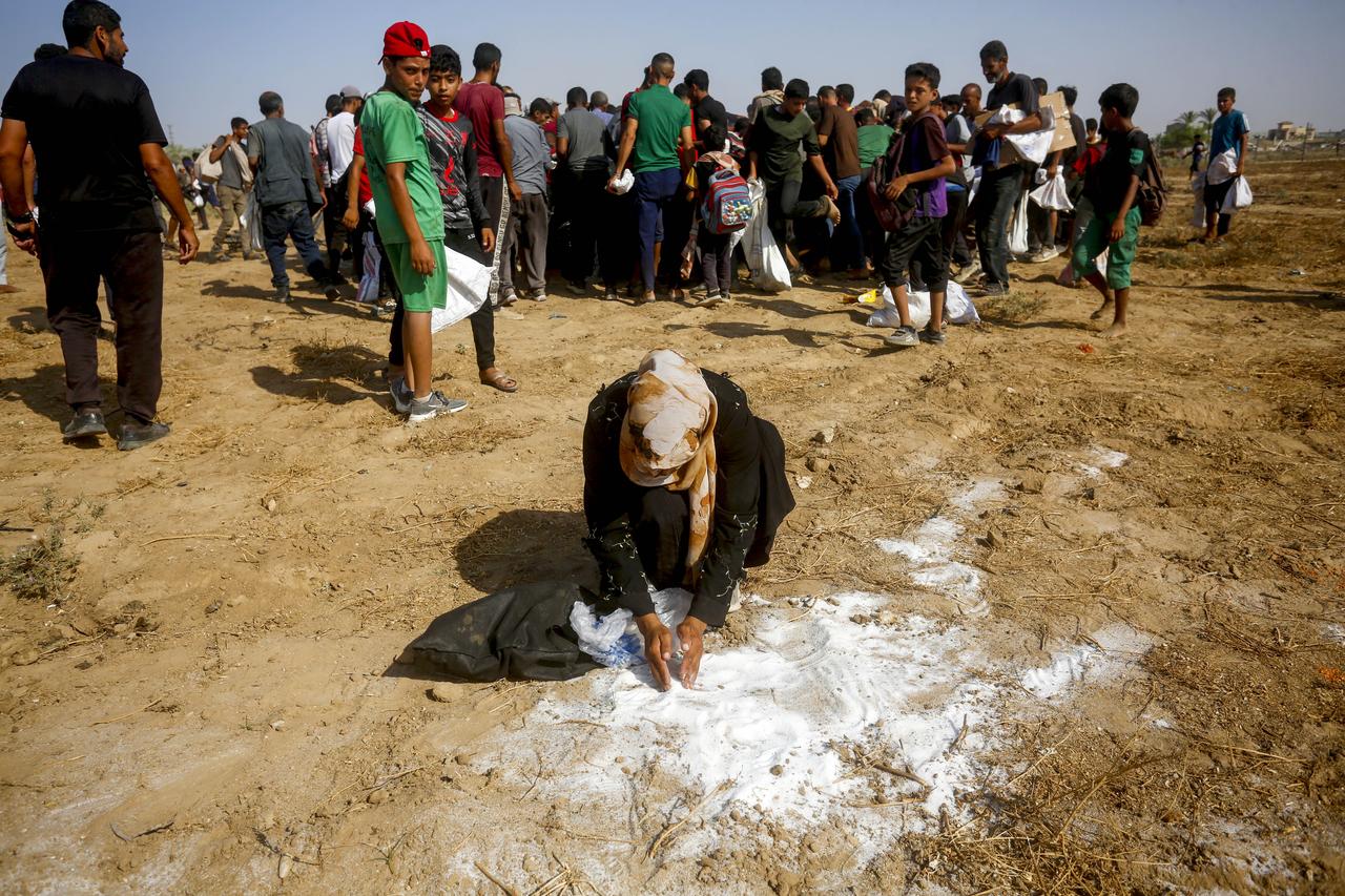 Palestinians flock toward parachutes carrying humanitarian aid after they landed in the central Gaza Strip city of Deir al-Balah, on August 15, 2025. (AA Photo)