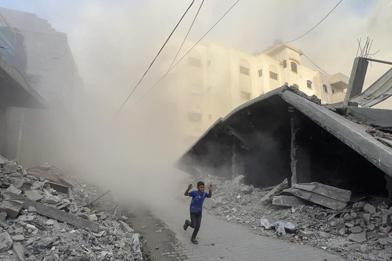 A Palestinian boy rushes away from the site of Israeli air strikes on a six-storey building in the Saftawi neighborhood west of Jabalia in the northern Gaza Strip on August 19, 2025. (AFP Photo)