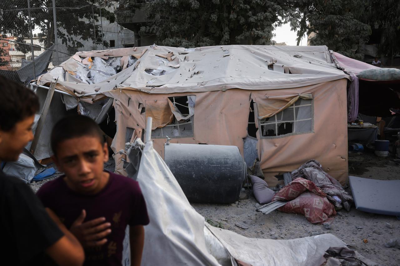 Palestinian youths gather near a damaged displacement tent following an Israeli strike in Saftawi neighborhood west of Jabalia, northern Gaza Strip on August 19, 2025. (AFP Photo)