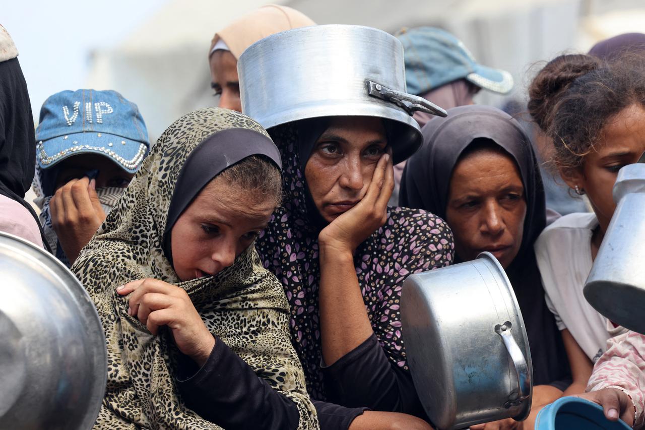 Palestinian women and children wait to receive food from a charity kitchen, in Khan Yunis in the southern Gaza Strip on August 21, 2025. (AFP Photo)
