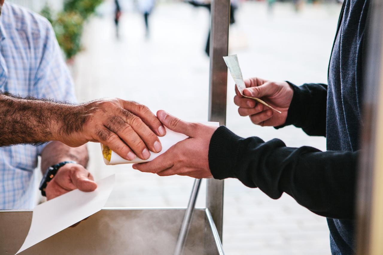 A street vendor sells cooked corn to a customer in Istanbul, Türkiye. (Adobe Stock Photo)